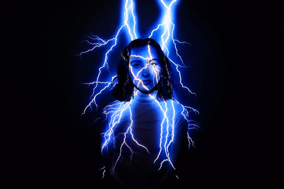 A woman in a white top, lightning projected on her