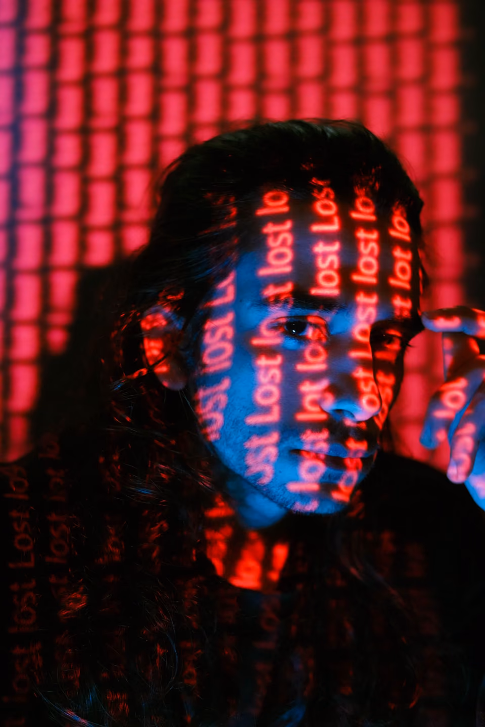 A man with words projected in red on his face